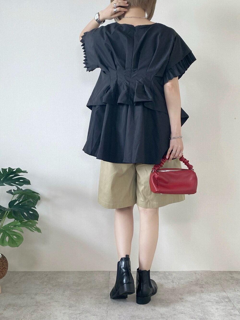 ブラック系のシャツ/ブラウス、ベージュ系のチノパンツ、レッド系のボストンバッグを着用したレディースの夏コーディネートの4枚目の写真