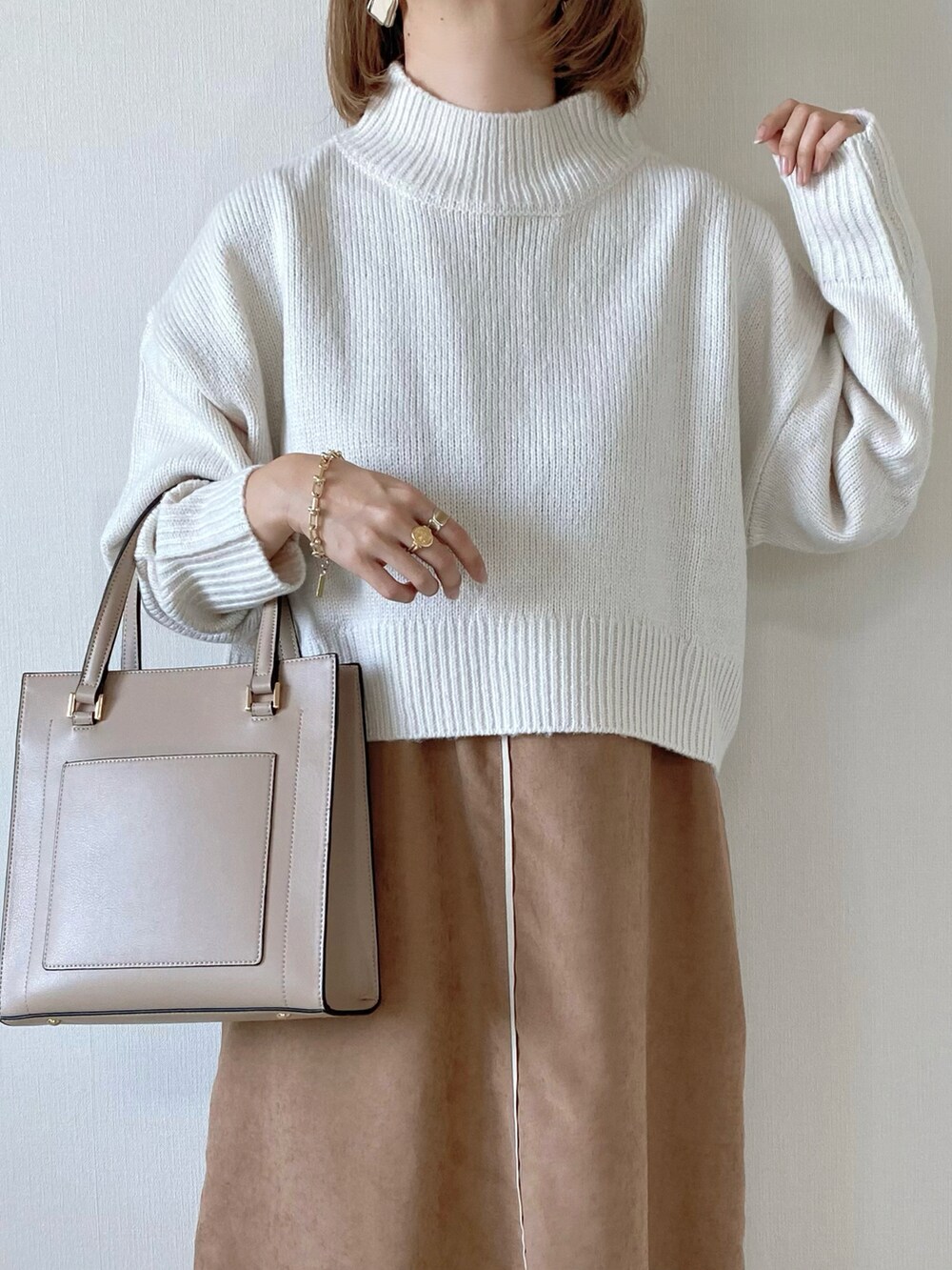 ホワイト系のニット/セーター、ブラウン系のワンピース、ホワイト系のブーツを着用したレディースの秋コーディネートの4枚目の写真