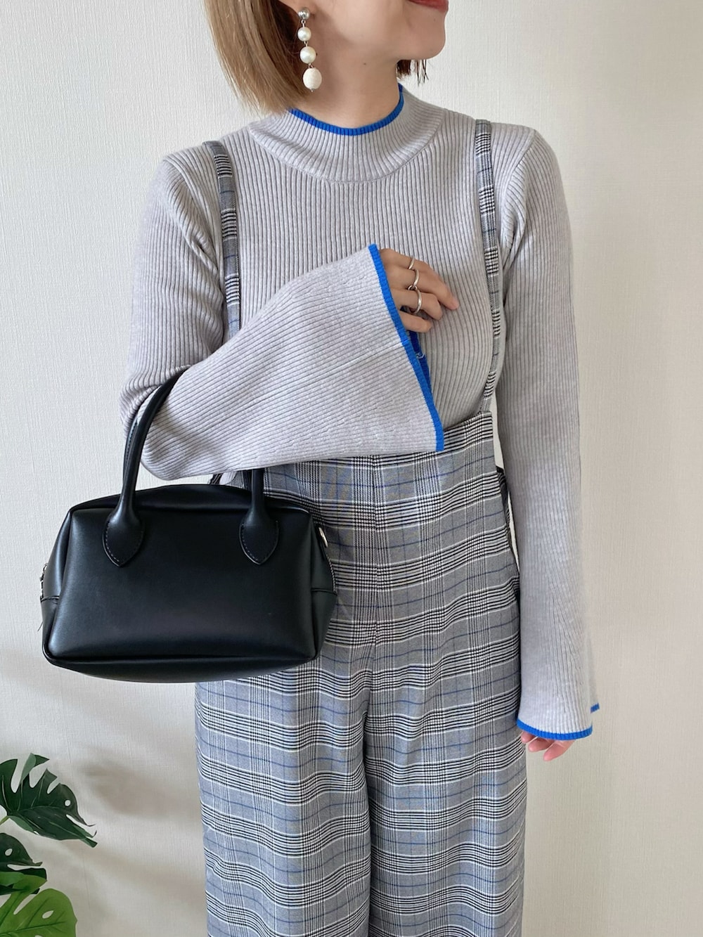 グレー系のニット/セーター、その他のサロペット/オーバーオール、ブラック系のバッグを着用したレディースの冬コーディネートの4枚目の写真