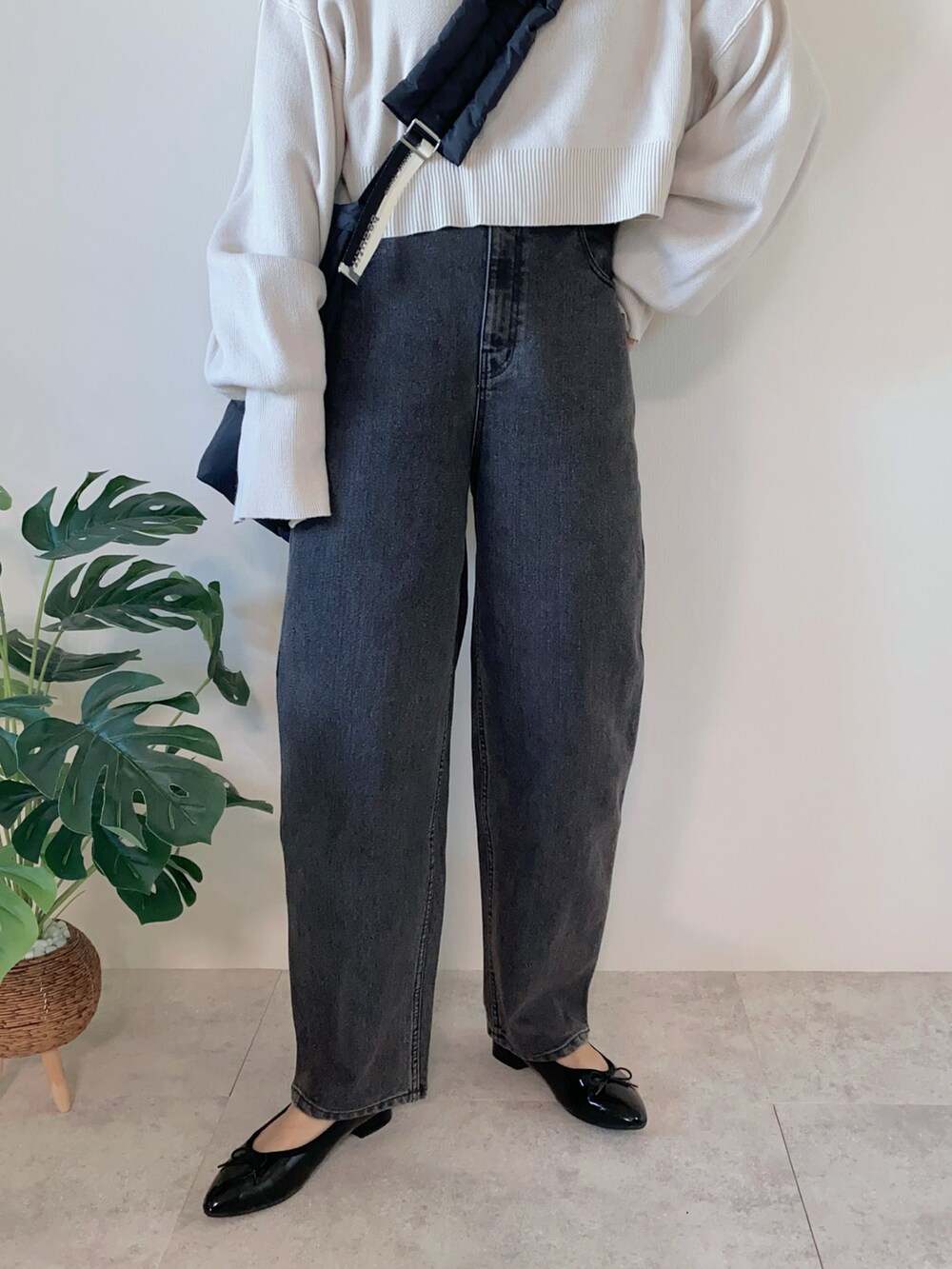 ブラック系のデニムパンツ、ブラック系のショルダーバッグ、ブラック系のパンプスを着用したレディースの冬コーディネートの4枚目の写真