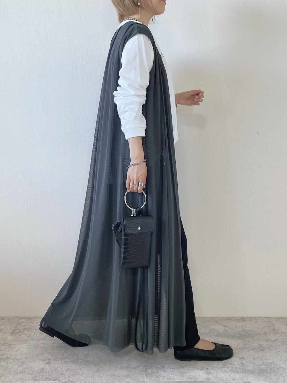 ブラック系のショルダーバッグ、その他のTシャツ/カットソー、グレー系のその他トップスを着用したレディースの秋コーディネートの2枚目の写真