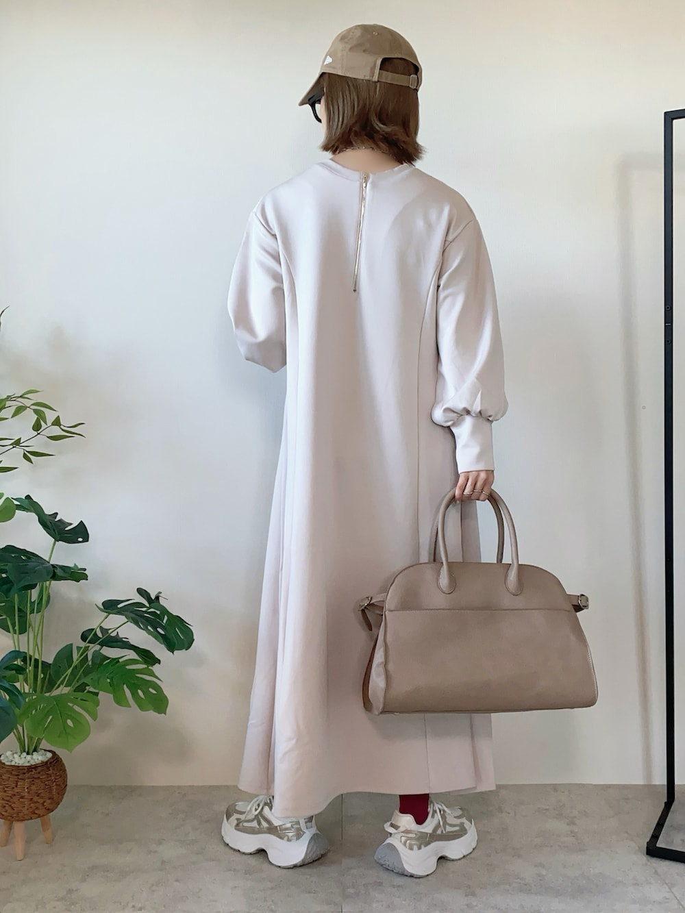 ホワイト系のワンピース、ベージュ系のボストンバッグ、ゴールド系のスニーカーを着用したレディースの春コーディネートの3枚目の写真