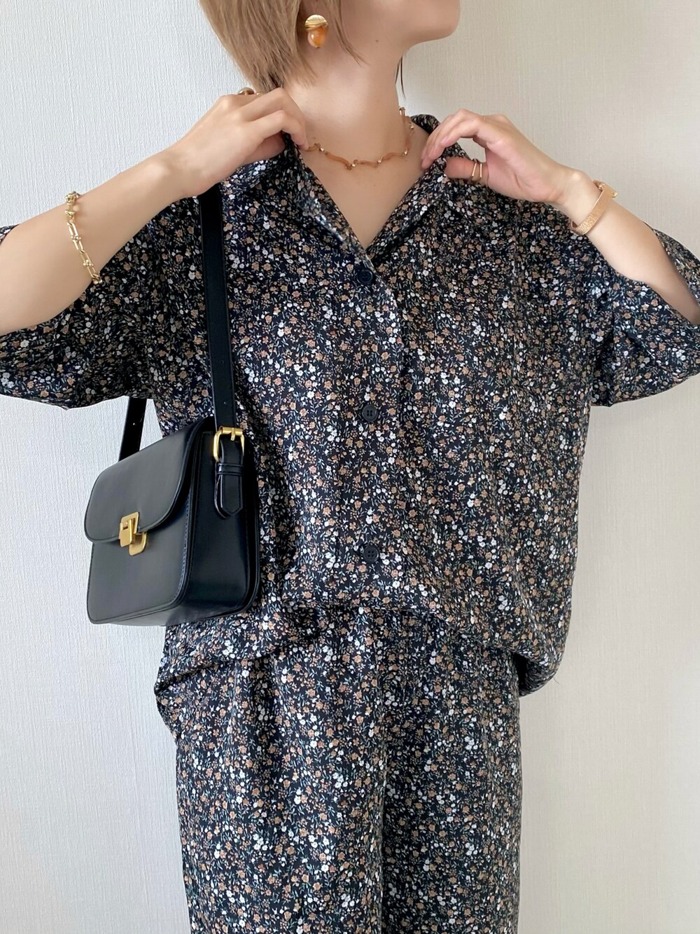 ブラック系のショルダーバッグ、ホワイト系のサンダル、ブラック系のシャツ/ブラウスを着用したレディースの夏コーディネートの3枚目の写真