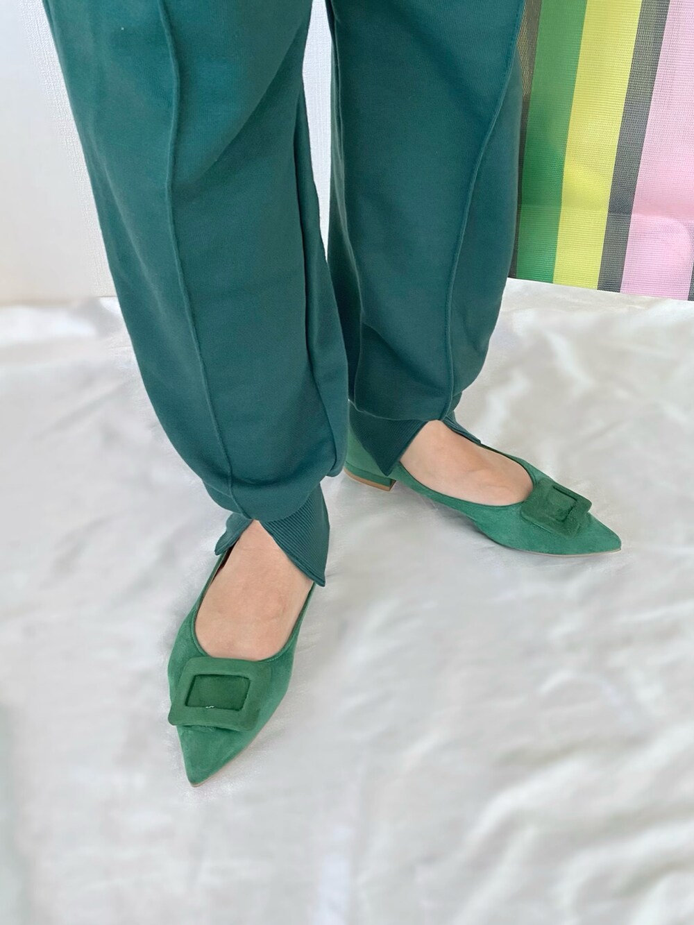 グリーン系のトートバッグ、グリーン系のパンプス、ホワイト系のニット/セーターを着用したレディースの秋コーディネートの5枚目の写真