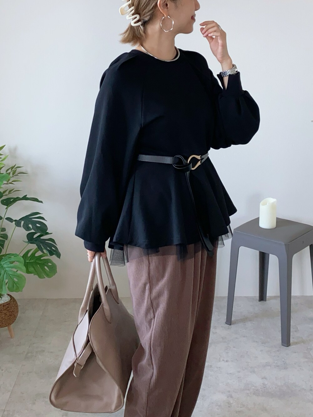 ブラック系のスウェット、ベージュ系のボストンバッグ、ブラック系のベルトを着用したレディースの秋コーディネートの3枚目の写真