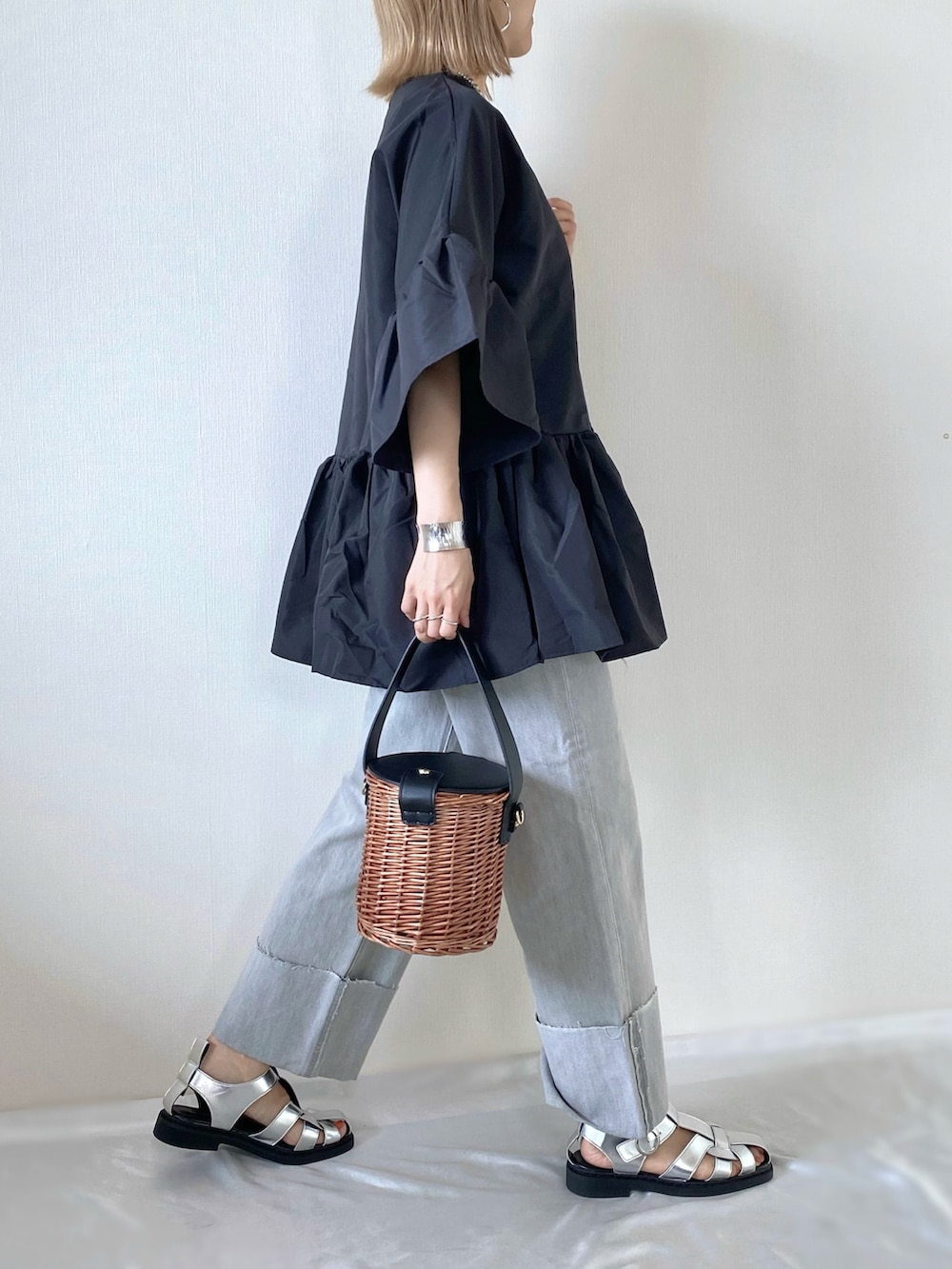 ブラック系のバッグ、シルバー系のサンダル、グレー系のデニムパンツを着用したレディースの夏コーディネートの4枚目の写真