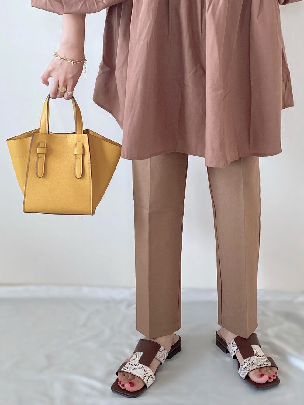 イエロー系のトートバッグ、ブラウン系のその他パンツ、ブラウン系のシャツ/ブラウスを着用したレディースの秋コーディネートの3枚目の写真