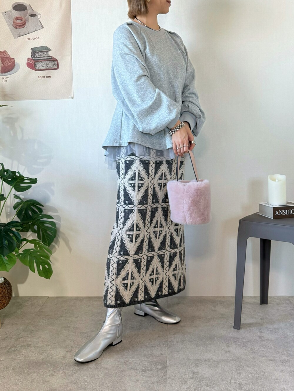 グレー系のスカート、グレー系のスウェット、シルバー系のブーツを着用したレディースの冬コーディネートの2枚目の写真