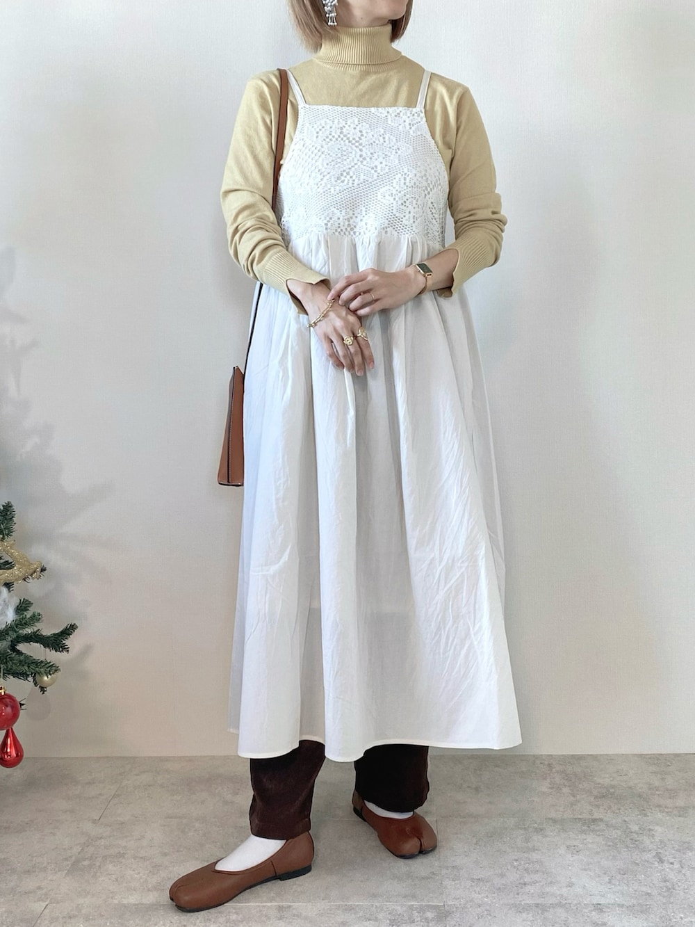 ホワイト系のワンピース、イエロー系のニット/セーター、ブラウン系のその他パンツを着用したレディースの冬コーディネートの2枚目の写真