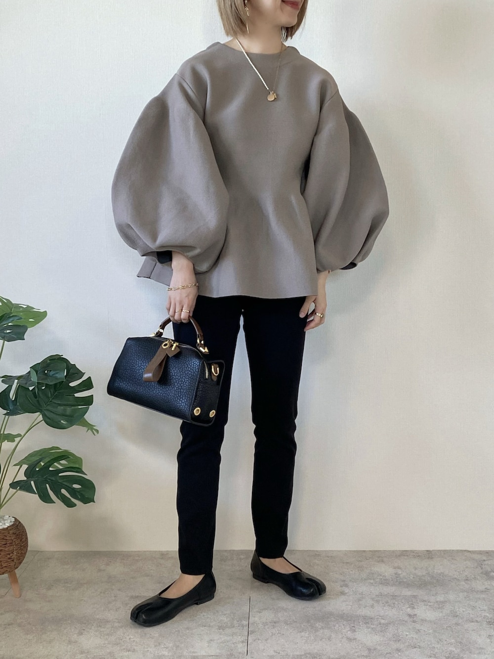 ブラウン系のTシャツ/カットソー、ブラック系のボストンバッグ、ブラック系のパンプスを着用したレディースの冬コーディネートの2枚目の写真