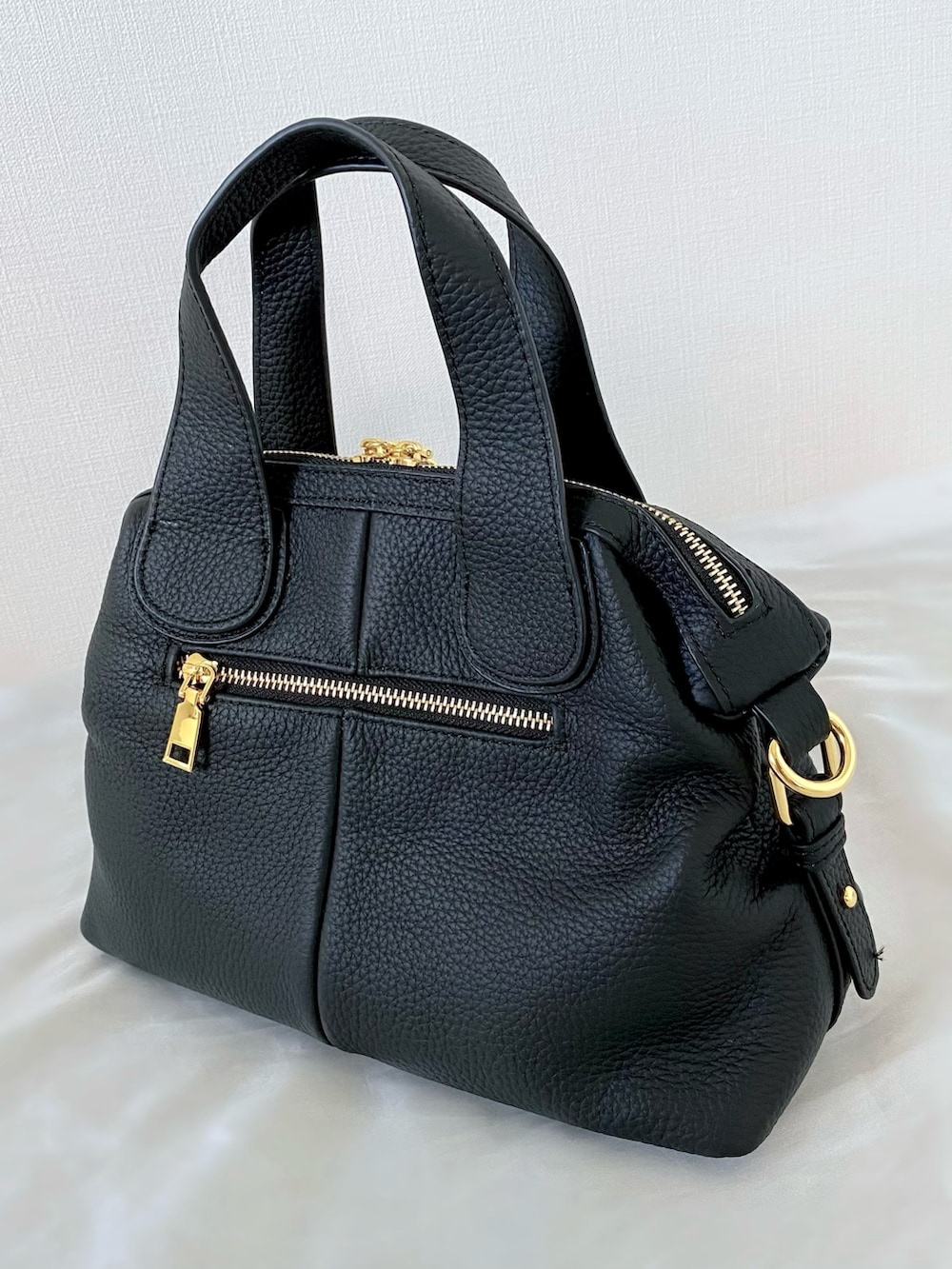 ブラック系のバッグ、ブルー系のベスト、ホワイト系のサンダルを着用したレディースの夏コーディネートの5枚目の写真