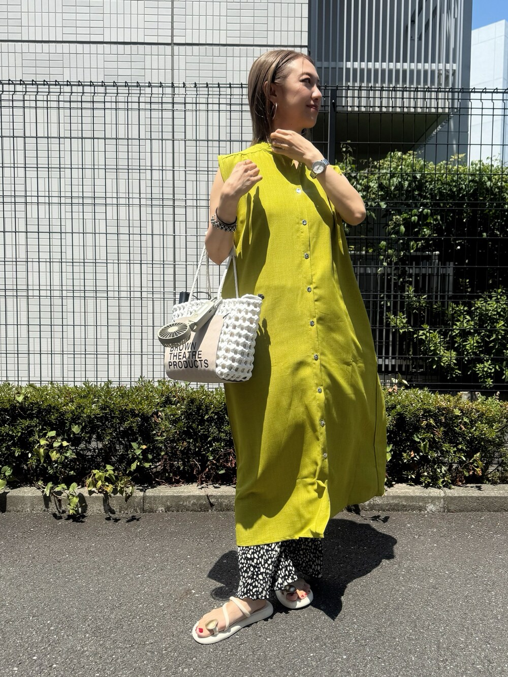 グリーン系のワンピース、ホワイト系のサンダル、ブラック系のその他パンツを着用したレディースの夏コーディネートの2枚目の写真