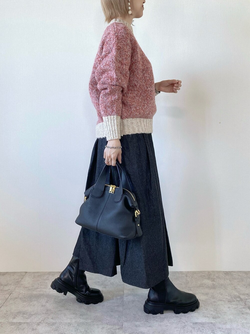 ピンク系のニット/セーター、ブラック系のバッグ、ブラック系のスカートを着用したレディースの秋コーディネートの3枚目の写真