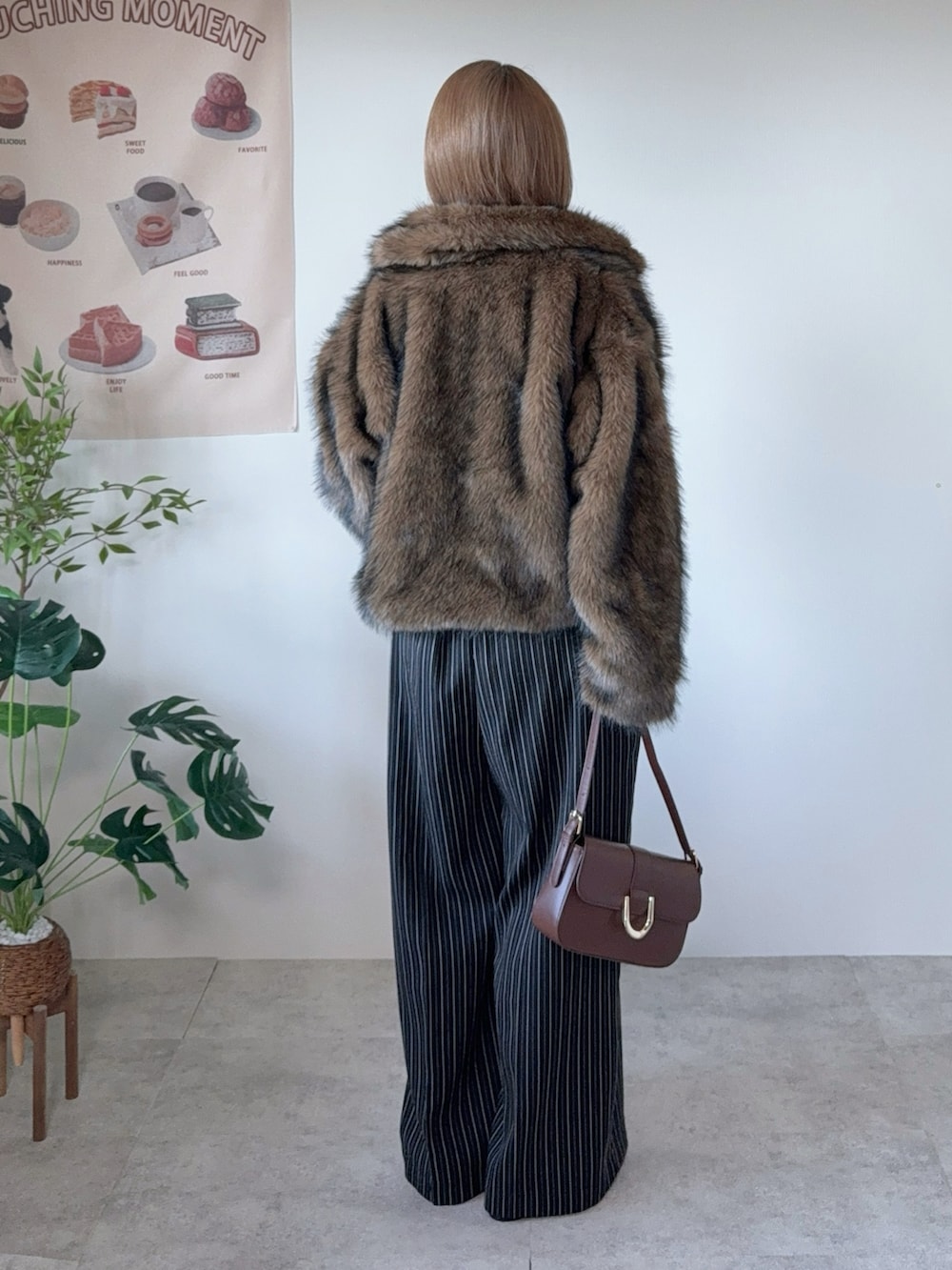 ブラウン系のブルゾン、ブラウン系のハンドバッグ、ブラック系のその他パンツを着用したレディースの冬コーディネートの4枚目の写真