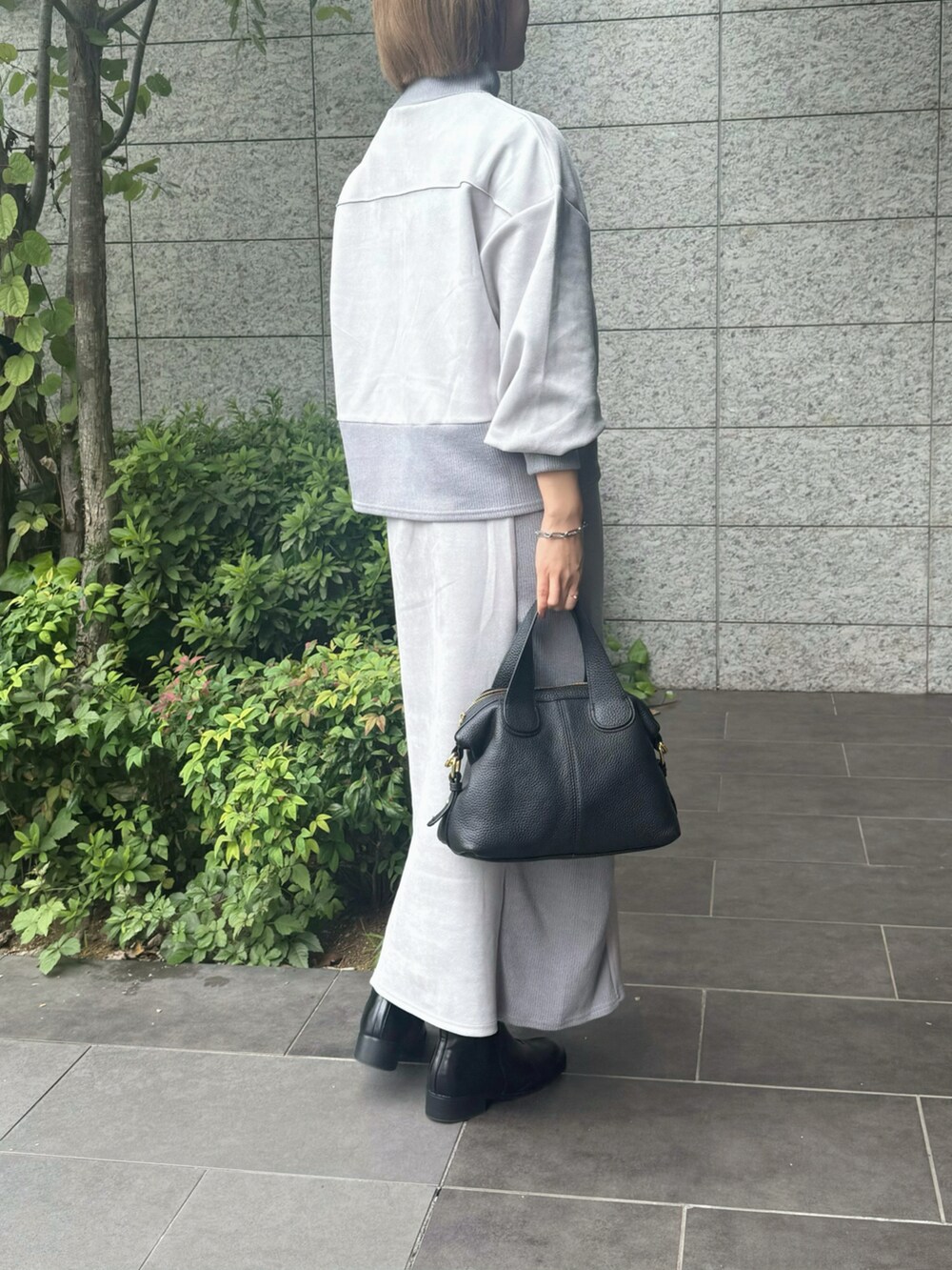 ブラック系のブーツ、ブラック系のバッグを着用したレディースの秋コーディネートの3枚目の写真