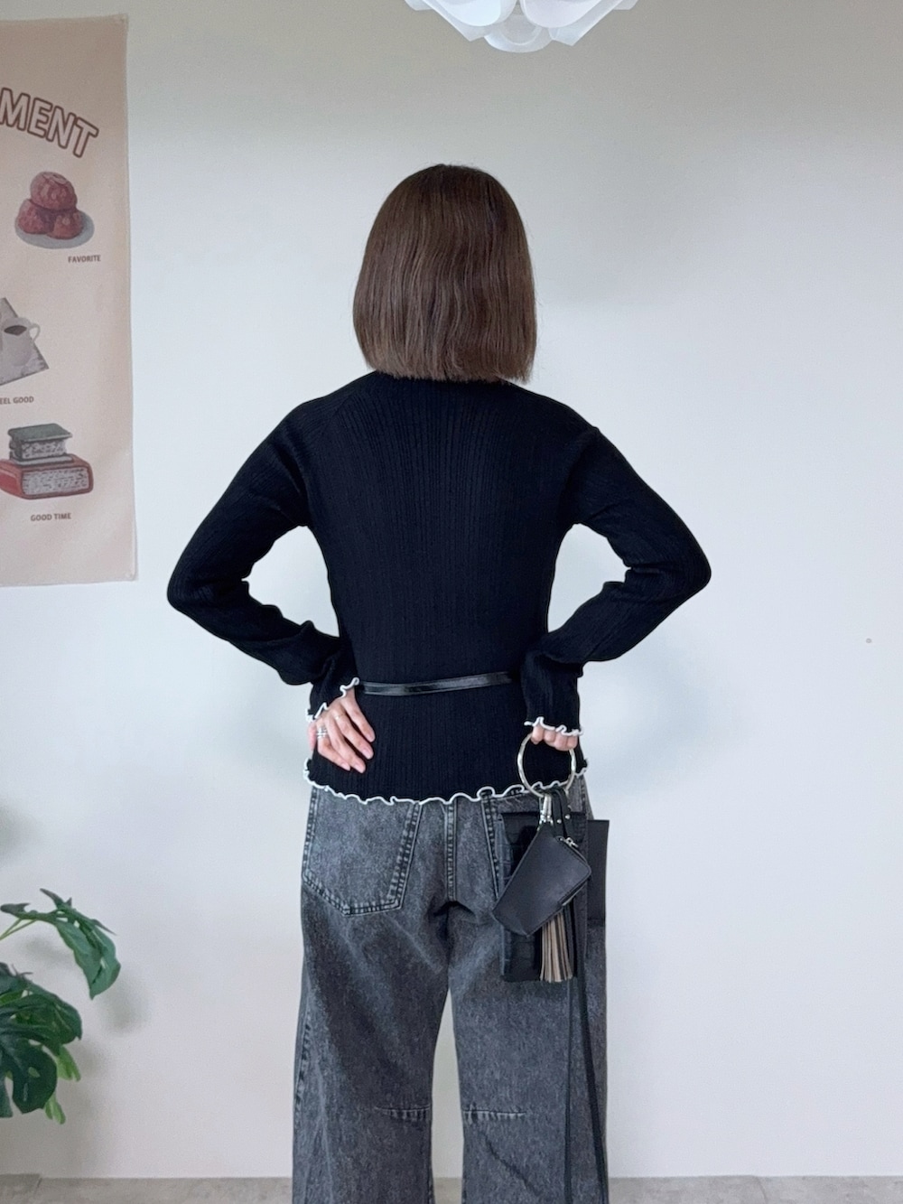 ブラック系のニット/セーター、グレー系のデニムパンツ、ブラック系のベルトを着用したレディースの秋コーディネートの5枚目の写真