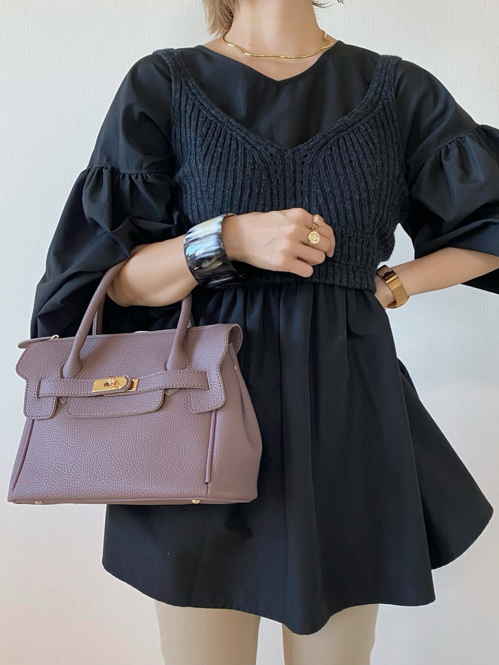 グレー系のニット/セーター、ゴールド系のネックレス、ブラック系のブレスレットを着用したレディースの秋コーディネートの3枚目の写真