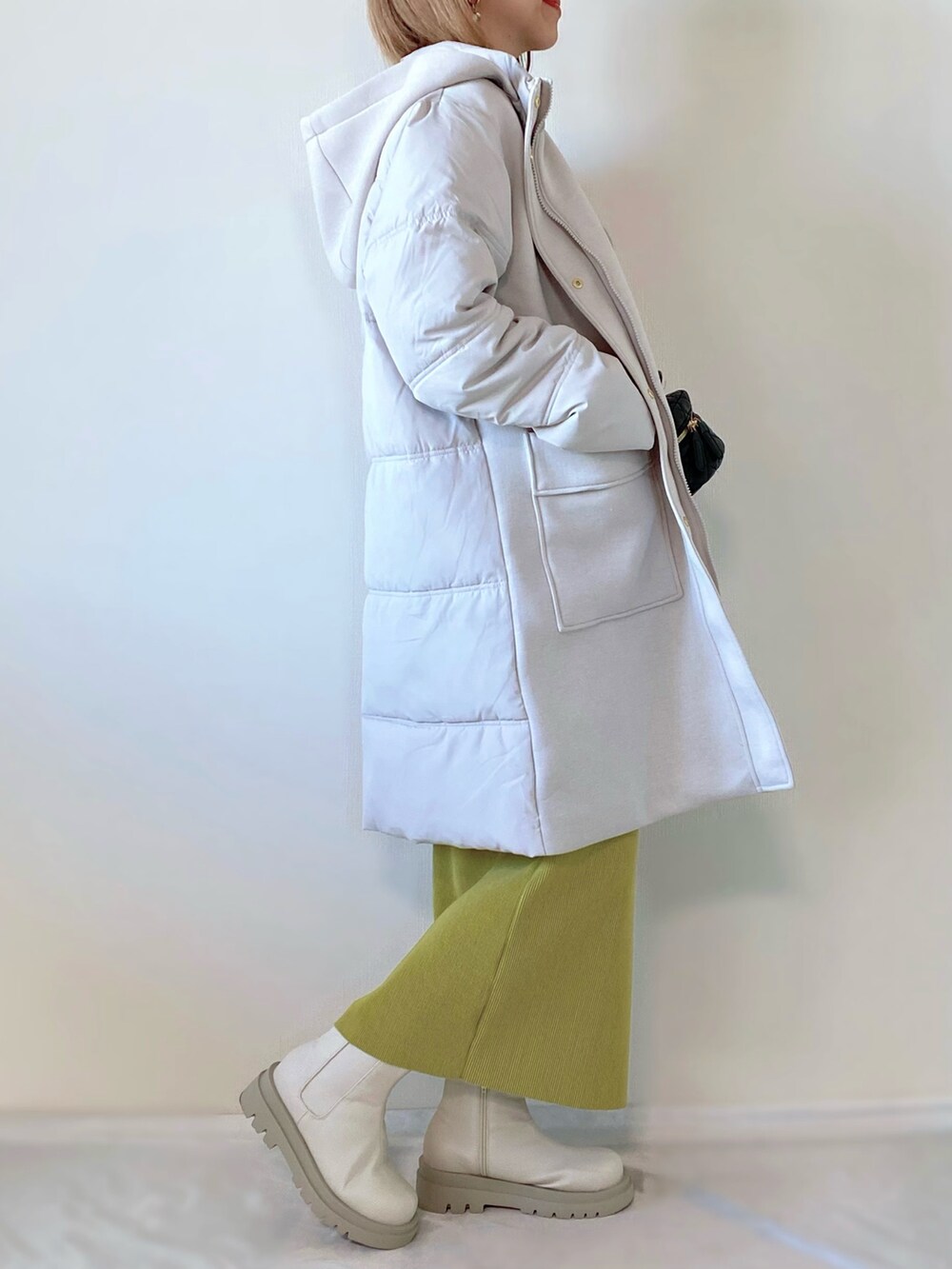 グレー系のダウンジャケット/コート、グレー系のニット/セーター、グリーン系のスカートを着用したレディースの冬コーディネートの2枚目の写真