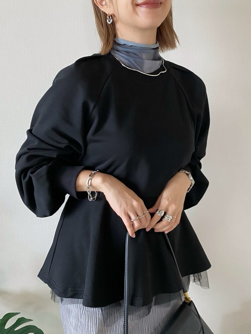 ブラック系のハンドバッグ、ブラック系のスウェット、グレー系のTシャツ/カットソーを着用したレディースの秋コーディネートの4枚目の写真