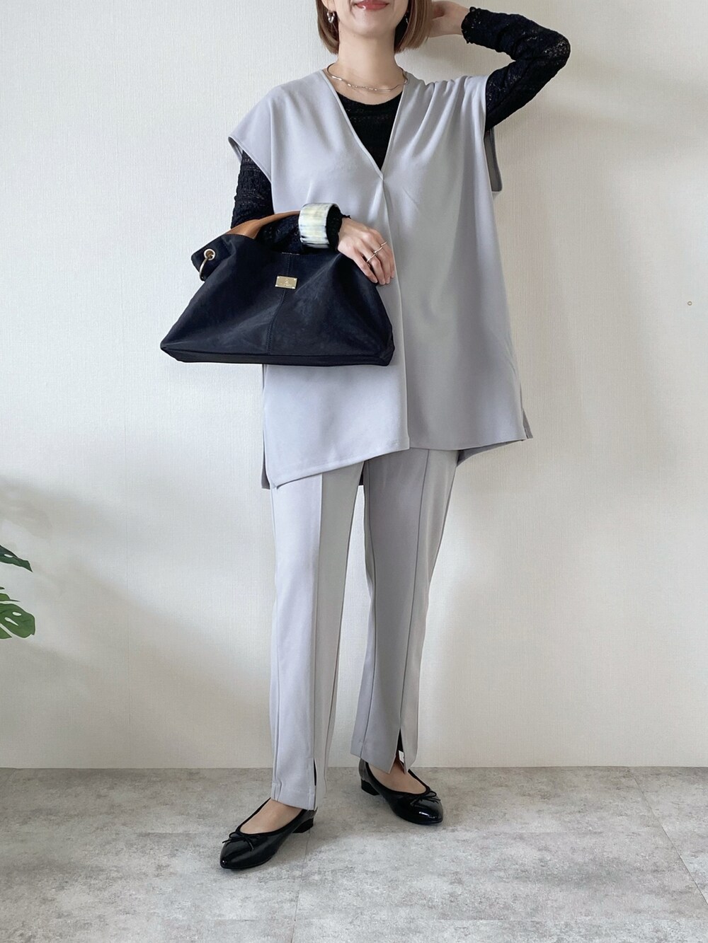 ブラック系のトートバッグ、グレー系のアンサンブル、グレー系のその他パンツを着用したレディースの春コーディネートの3枚目の写真
