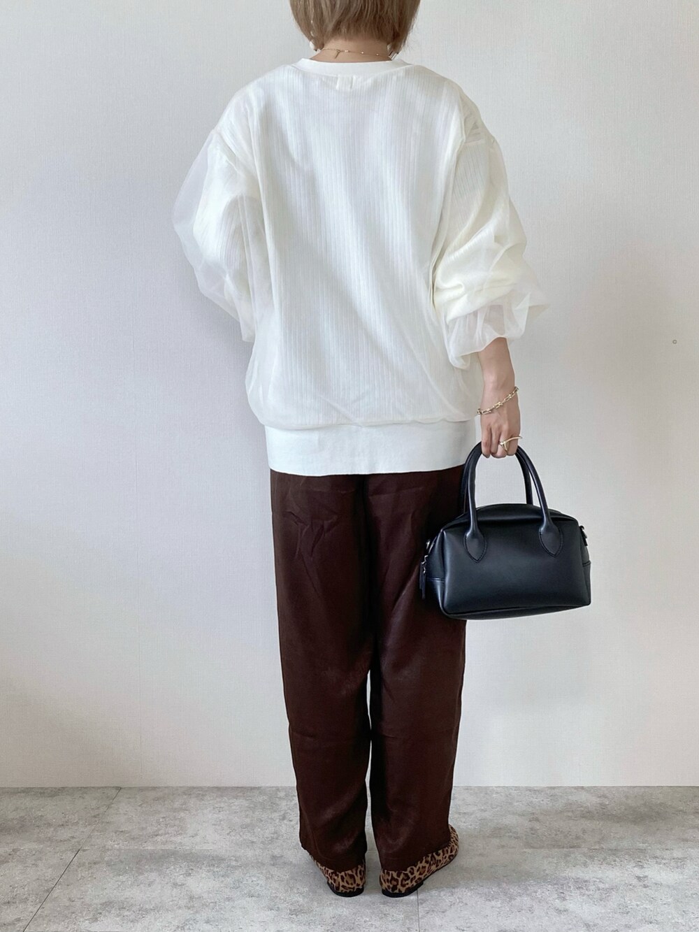 ホワイト系のカーディガン/ボレロ、ブラウン系のその他パンツ、ブラウン系のバレエシューズを着用したレディースの秋コーディネートの5枚目の写真