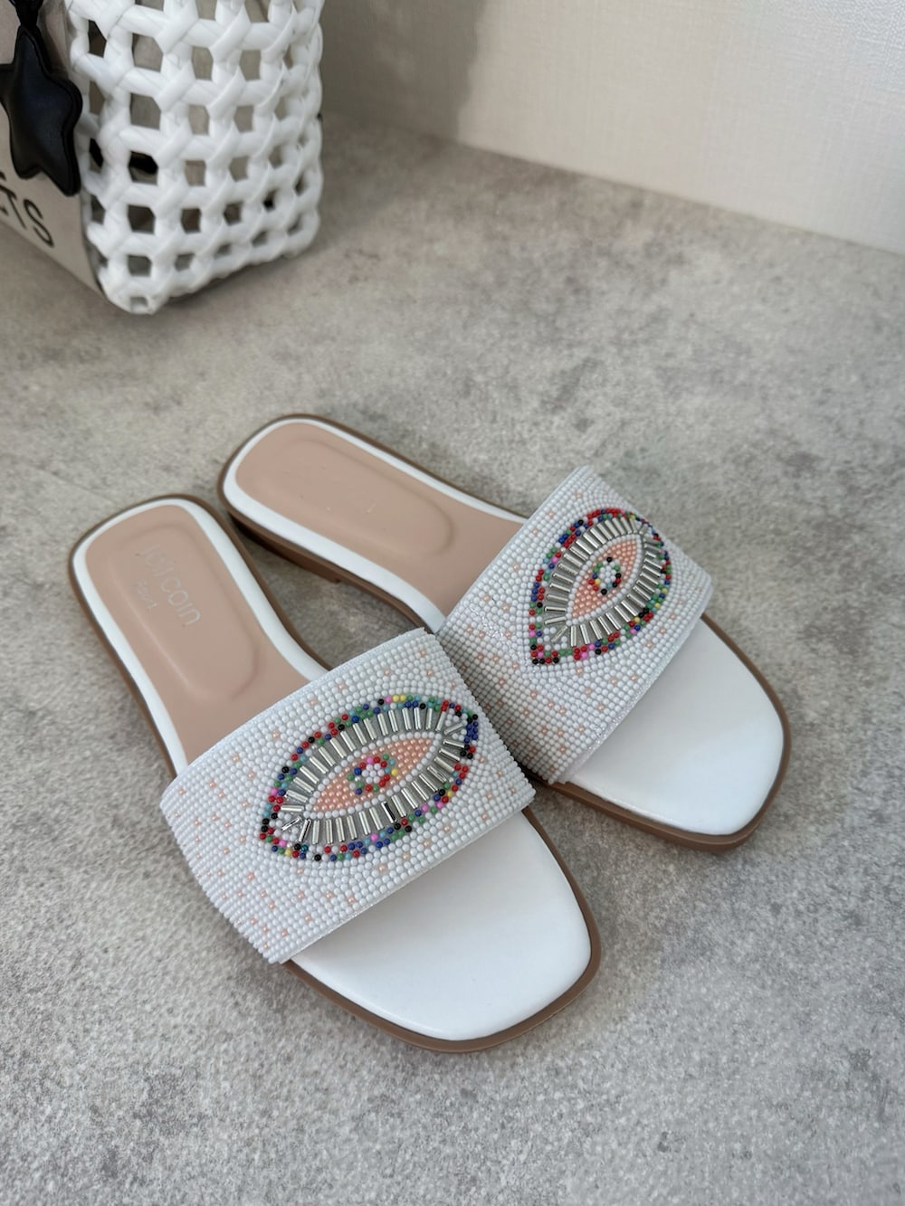 ホワイト系のサンダル、ホワイト系のかごバッグ、シルバー系のネックレスを着用したレディースの夏コーディネートの5枚目の写真