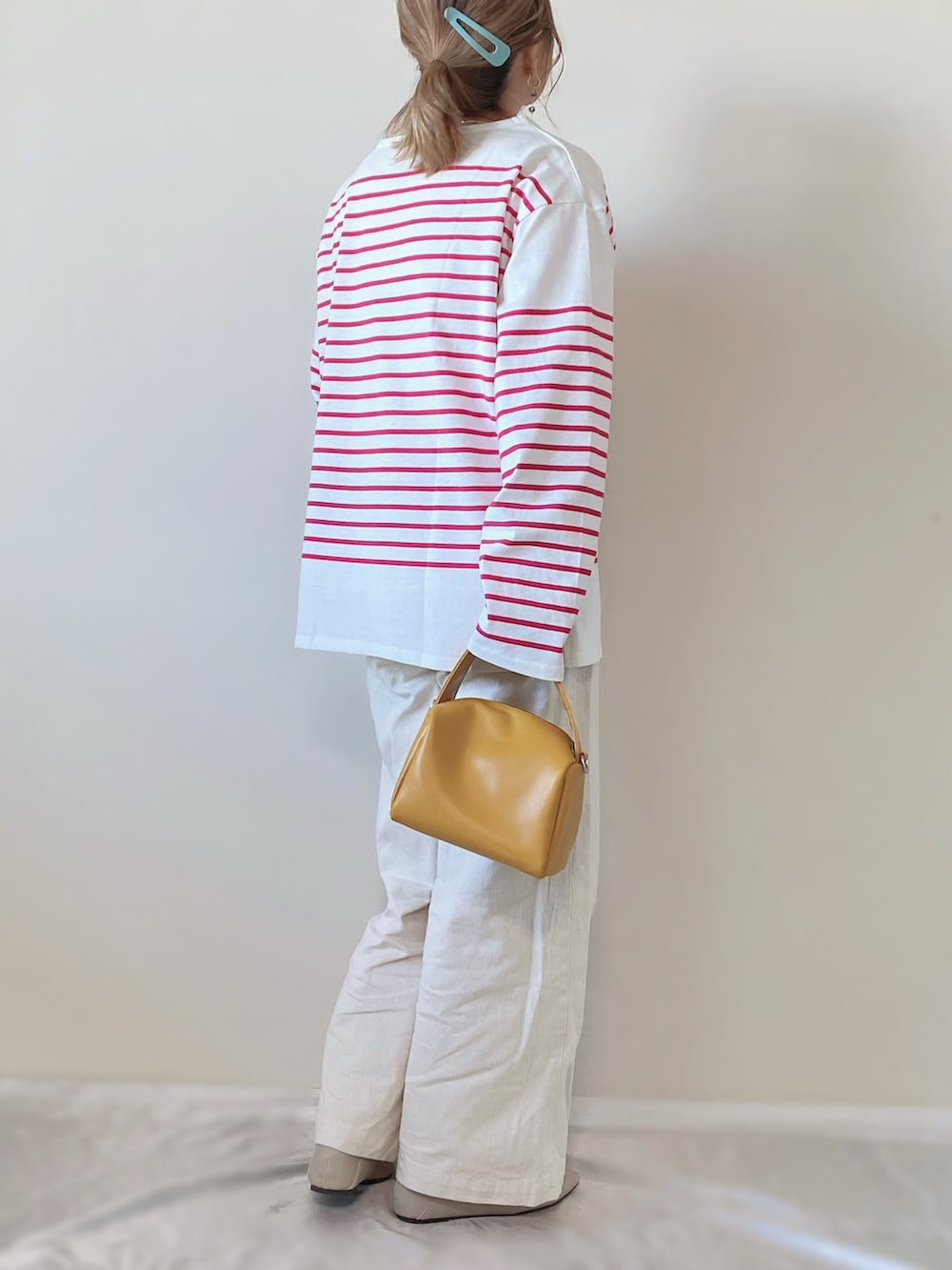 ピンク系のTシャツ/カットソー、イエロー系のバッグ、ホワイト系のローファーを着用したレディースの春コーディネートの2枚目の写真