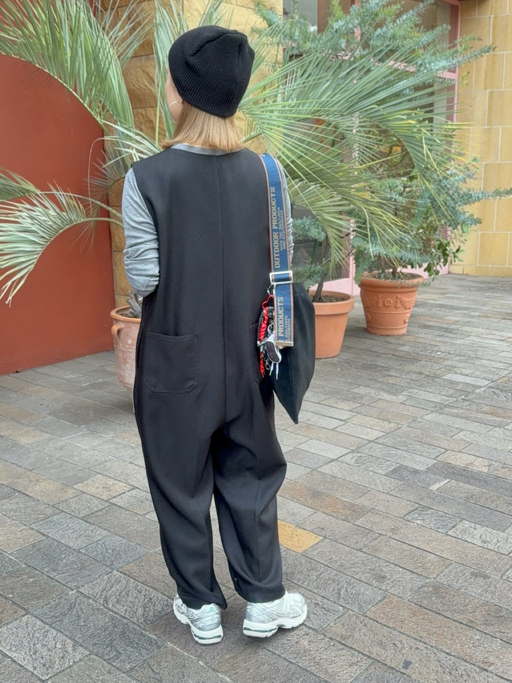 シルバー系のスニーカー、ブラック系のトートバッグ、ブラック系のつなぎ/オールインワンを着用したレディースの秋コーディネートの2枚目の写真