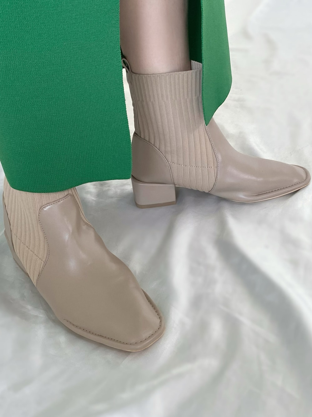 グリーン系のニット/セーター、グリーン系のスカート、ベージュ系のブーツを着用したレディースの秋コーディネートの4枚目の写真