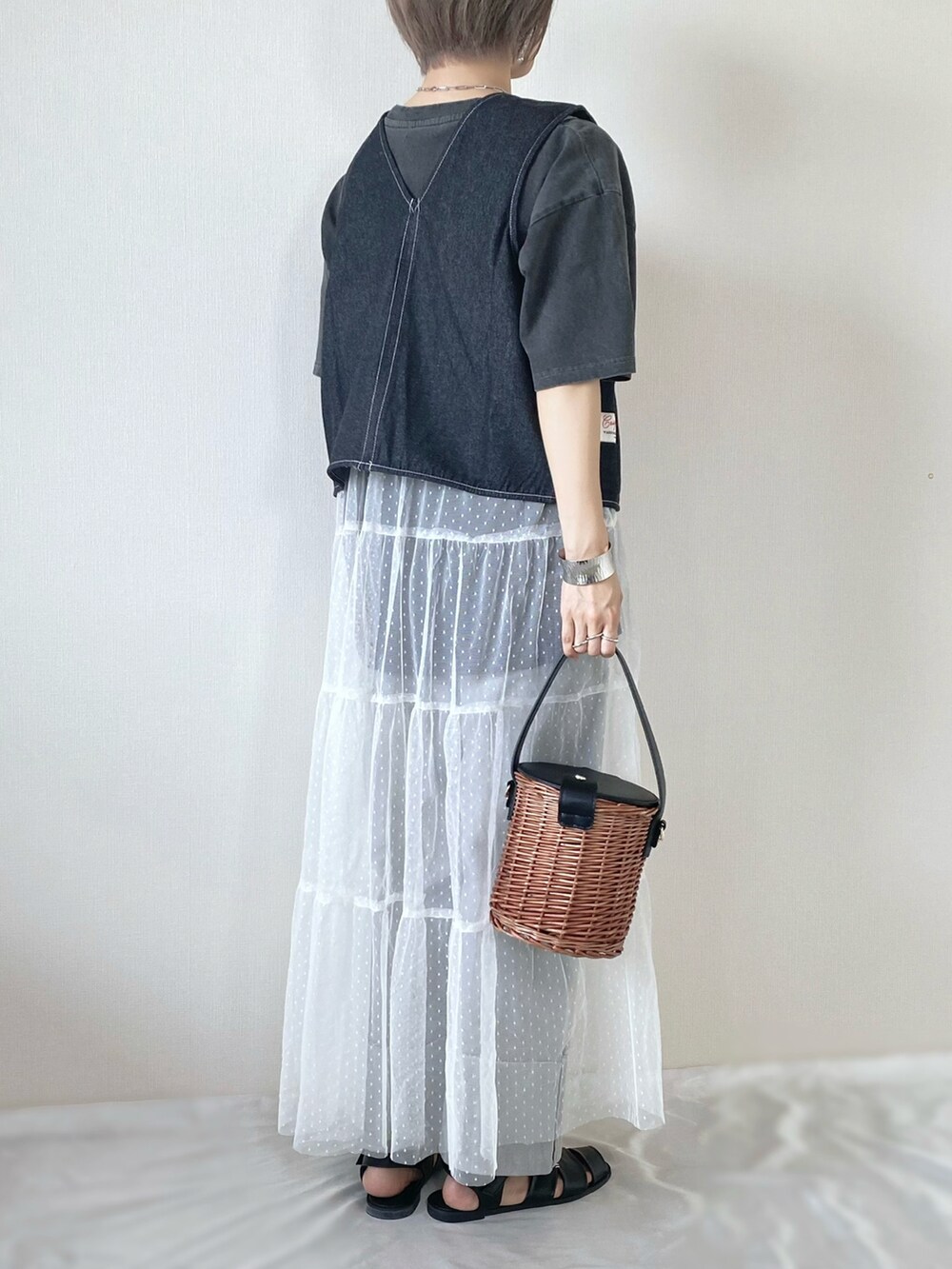 ブラック系のバッグ、ブラック系のサンダル、グレー系のデニムパンツを着用したレディースの夏コーディネートの2枚目の写真