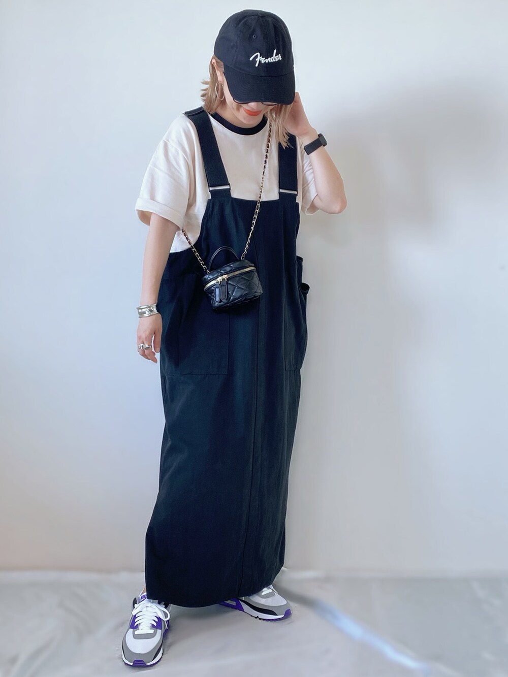 ブラック系のスカート、ブラック系のショルダーバッグ、パープル系のスニーカーを着用したレディースの秋コーディネートの2枚目の写真