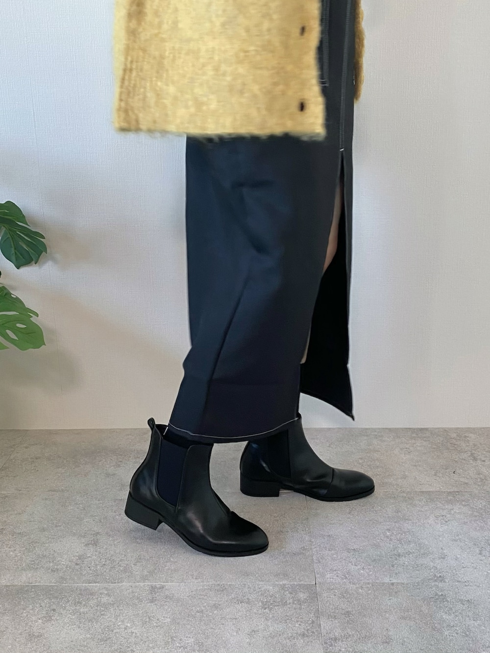 ブラック系のワンピース、ブラック系のブーツ、ブラック系のバッグを着用したレディースの冬コーディネートの4枚目の写真