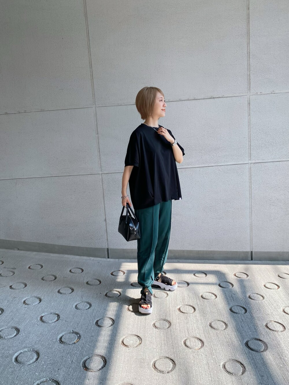 グリーン系のスウェットパンツ、ブラック系のTシャツ/カットソー、ブラック系のバッグを着用したレディースの夏コーディネートの2枚目の写真