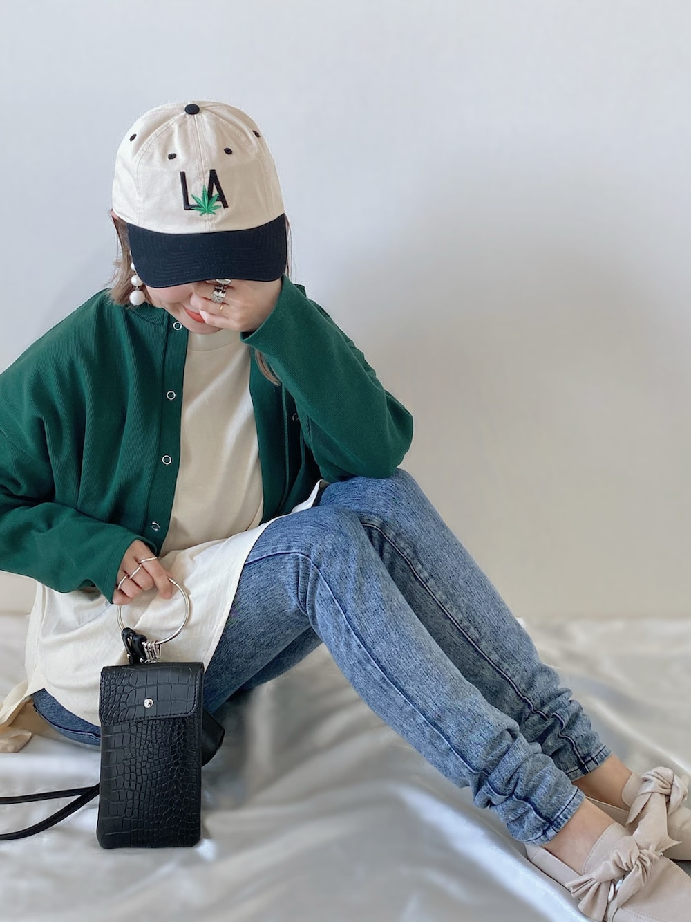 グリーン系のカーディガン/ボレロ、ベージュ系のTシャツ/カットソー、ブラック系のショルダーバッグを着用したレディースの春コーディネートの2枚目の写真