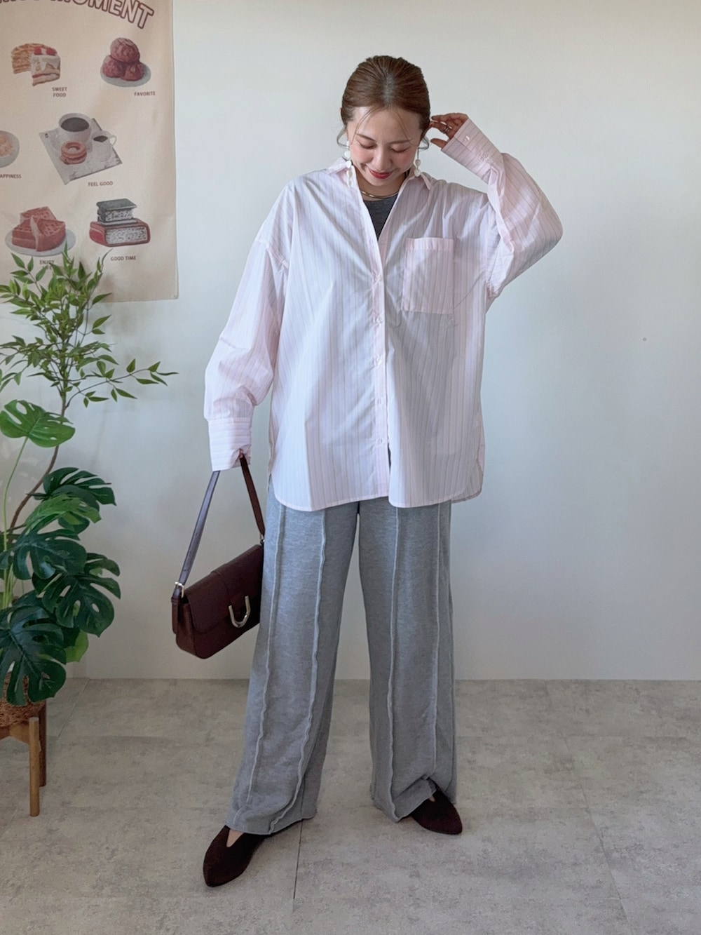 ピンク系のシャツ/ブラウス、グレー系のスウェットパンツ、ブラウン系のハンドバッグを着用したレディースの春コーディネートの4枚目の写真