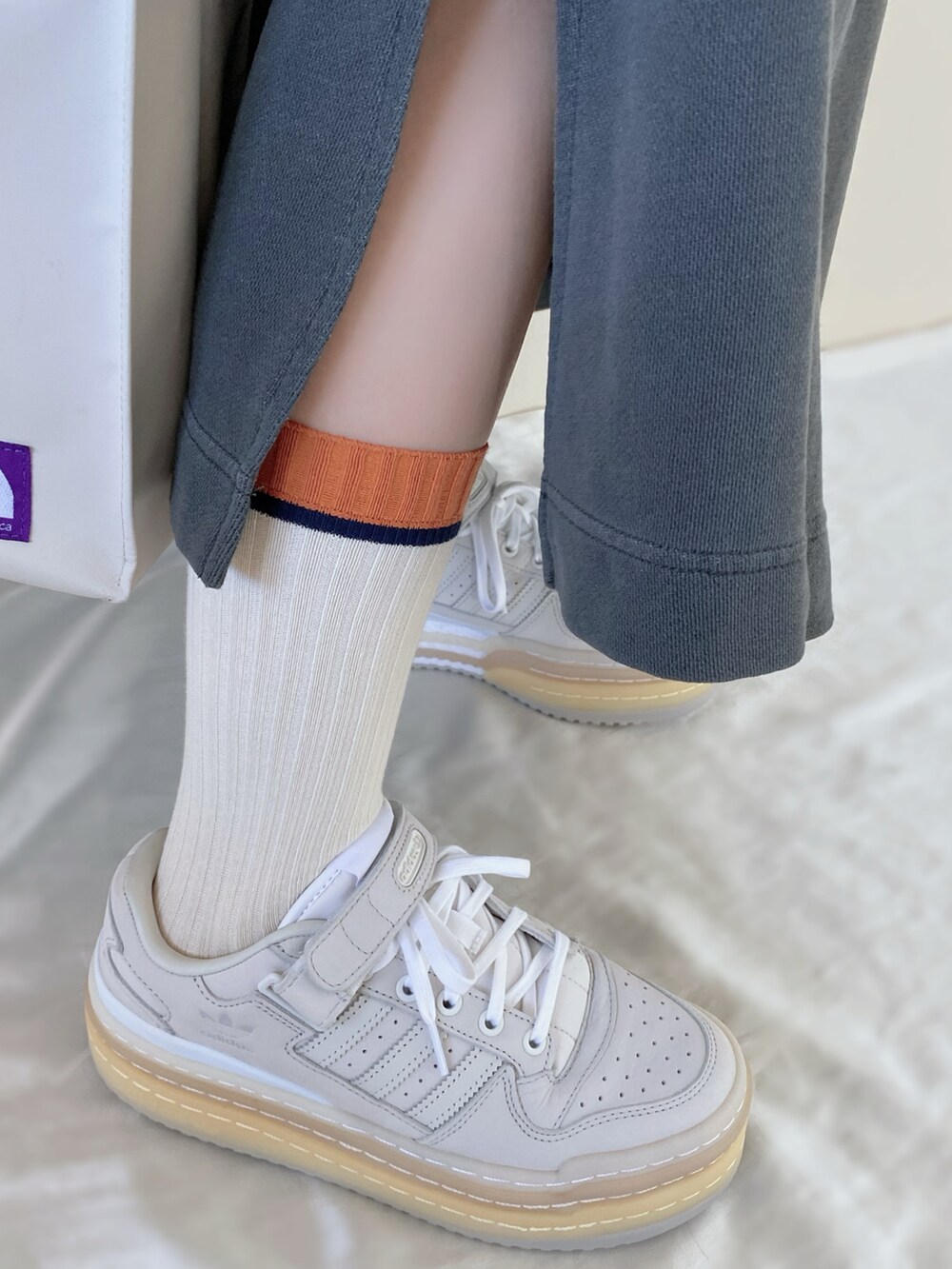 ベージュ系のトートバッグ、グレー系のワンピース、ホワイト系のスニーカーを着用したレディースの冬コーディネートの3枚目の写真