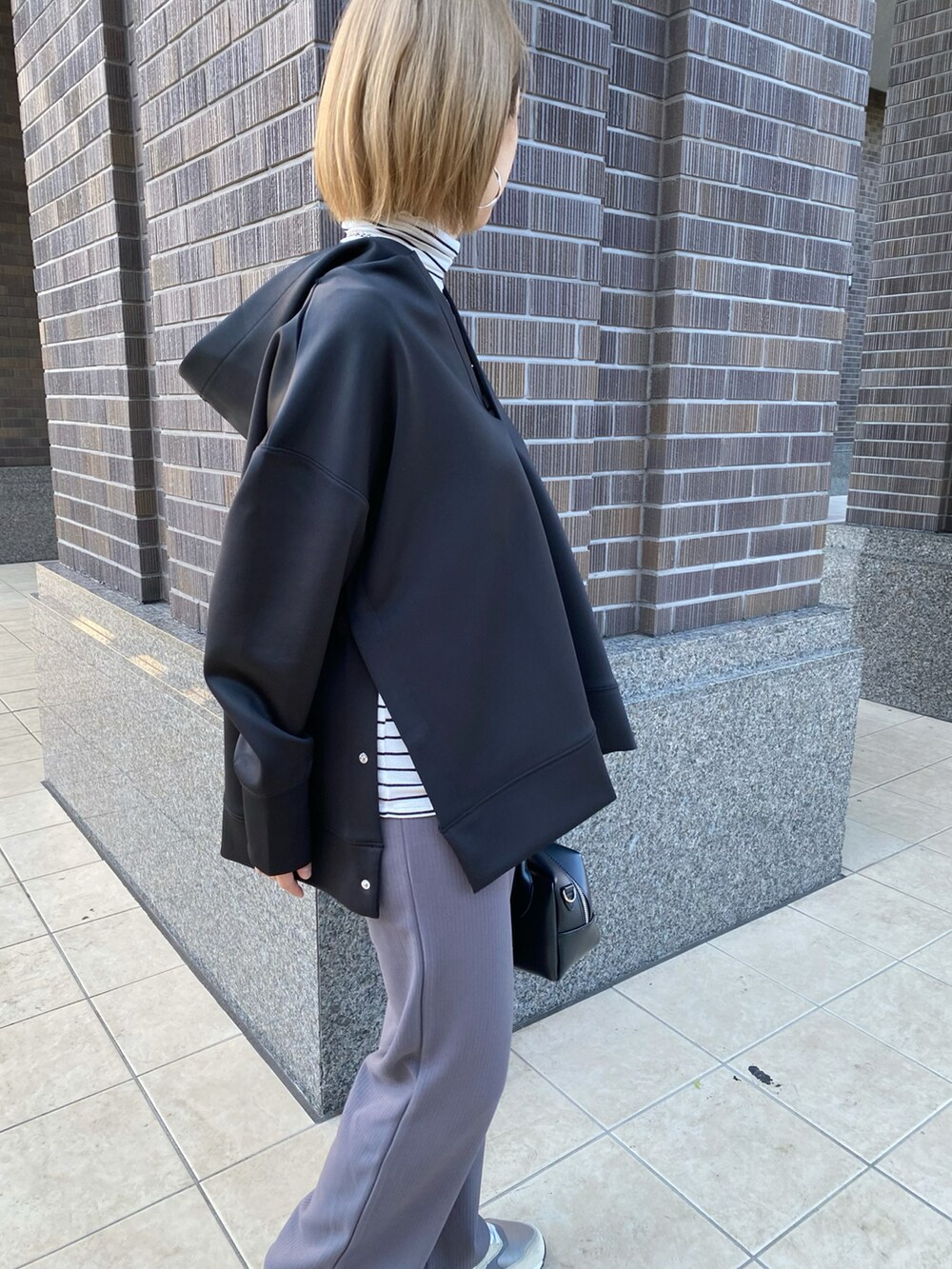 ブラック系のパーカー、グレー系のその他パンツ、ホワイト系のTシャツ/カットソーを着用したレディースの秋コーディネートの3枚目の写真