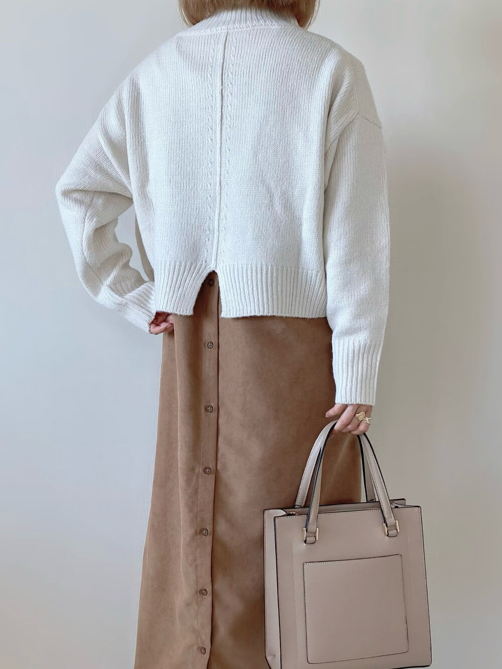 ホワイト系のニット/セーター、ブラウン系のワンピース、ホワイト系のブーツを着用したレディースの秋コーディネートの5枚目の写真