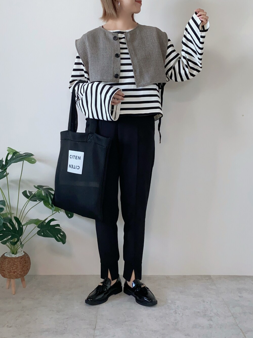 ブラック系のTシャツ/カットソー、ブラック系のベスト、ブラック系のトートバッグを着用したレディースの夏コーディネートの2枚目の写真