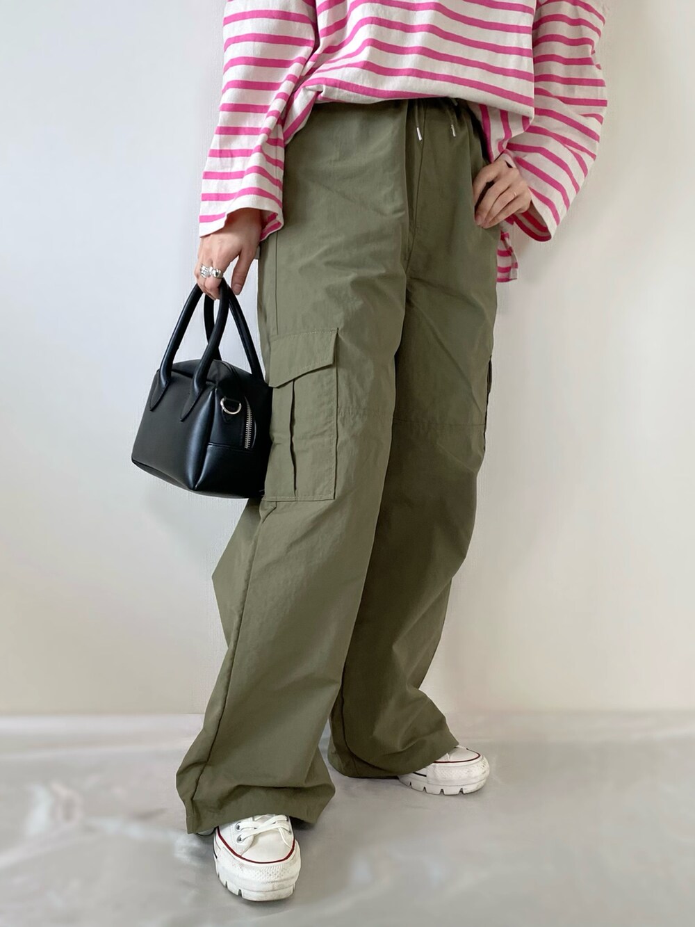 ブラック系のバッグ、グリーン系のカーゴパンツ、ホワイト系のスニーカーを着用したレディースの冬コーディネートの4枚目の写真