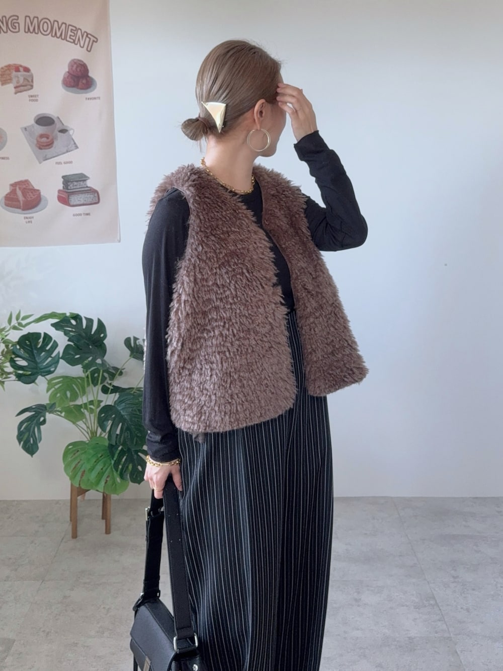 ブラック系のショルダーバッグ、ブラウン系のベスト、ブラック系のその他パンツを着用したレディースの秋コーディネートの4枚目の写真