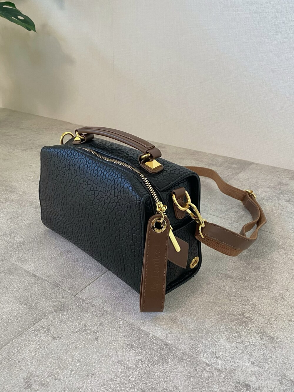 ブラック系のボストンバッグ、グリーン系のニット/セーター、ブラック系のパンプスを着用したレディースの冬コーディネートの5枚目の写真