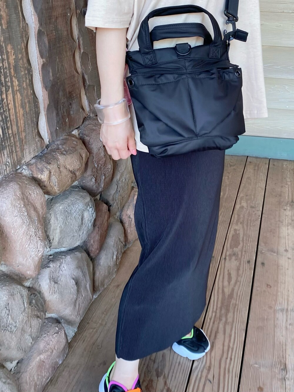 ブラック系のスカート、ブラック系のサンダル、ブラック系のショルダーバッグを着用したレディースの夏コーディネートの2枚目の写真