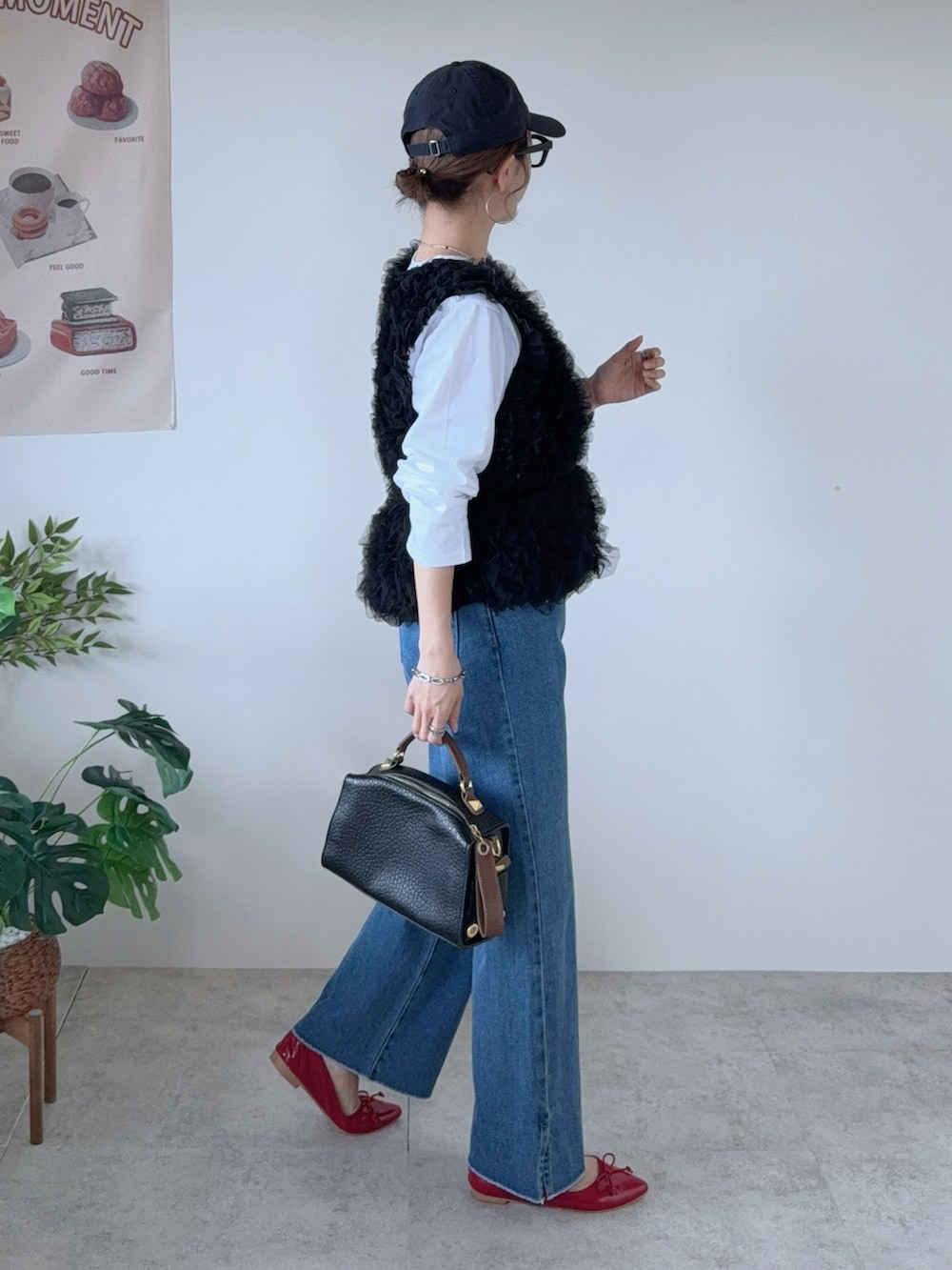 ブラック系のベスト、ブルー系のデニムパンツ、レッド系のバレエシューズを着用したレディースの秋コーディネートの3枚目の写真