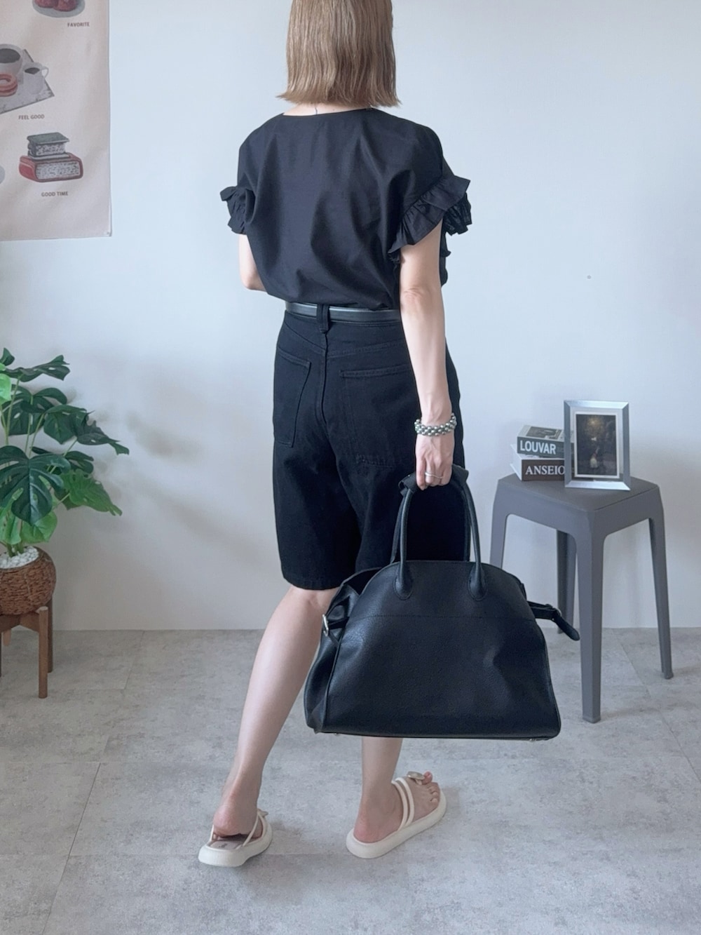 ブラック系のシャツ/ブラウス、ブラック系のボストンバッグ、ホワイト系のサンダルを着用したレディースの夏コーディネートの2枚目の写真