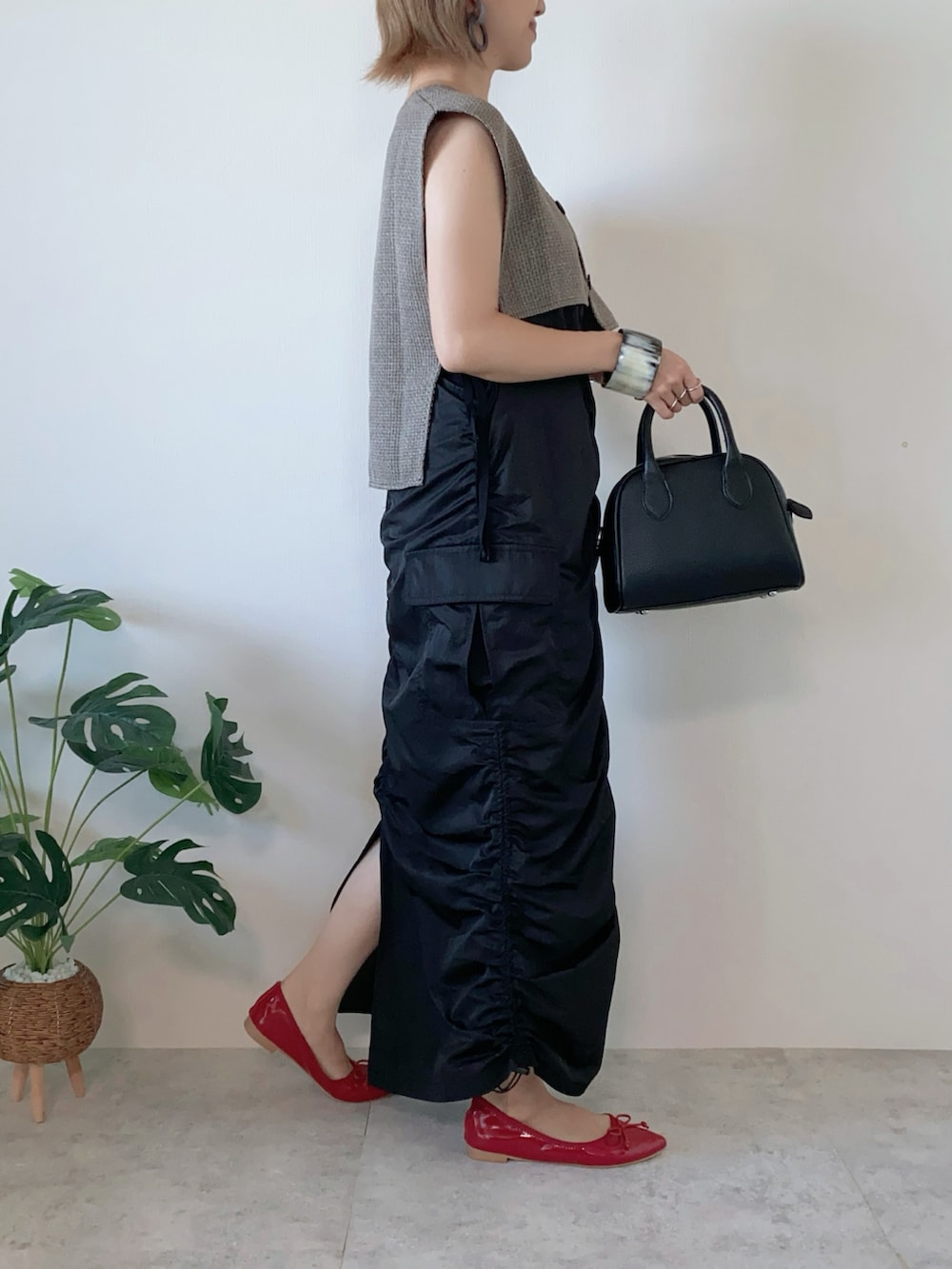ブラック系のワンピース、ブラック系のボストンバッグ、レッド系のバレエシューズを着用したレディースの夏コーディネートの5枚目の写真