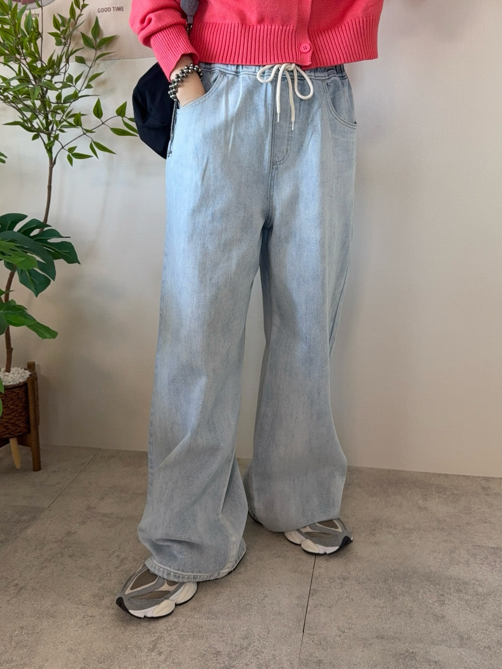 ブルー系のデニムパンツ、ブラック系のショルダーバッグ、グレー系のスニーカーを着用したレディースの春コーディネートの5枚目の写真