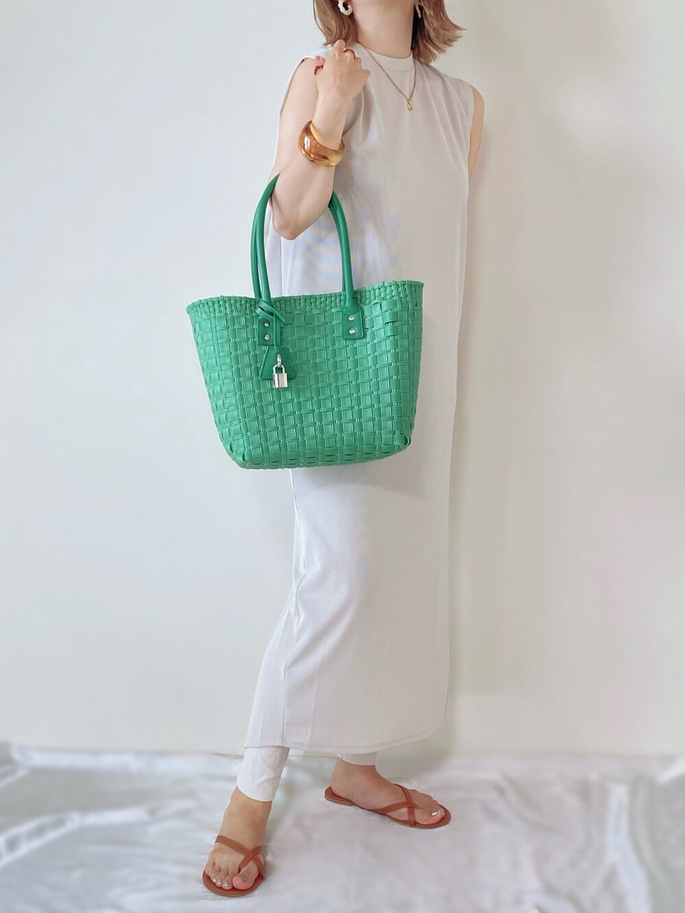 グリーン系のバッグ、ベージュ系のワンピースを着用したレディースの夏コーディネートの2枚目の写真