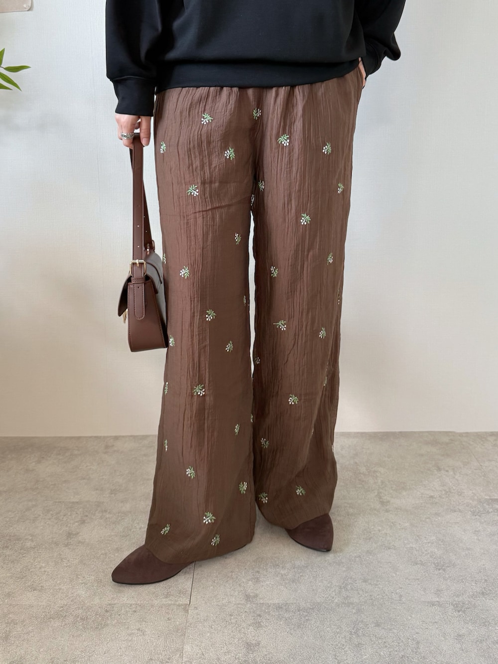 ブラック系のTシャツ/カットソー、ブラウン系のその他パンツ、ブラウン系のハンドバッグを着用したレディースの春コーディネートの5枚目の写真