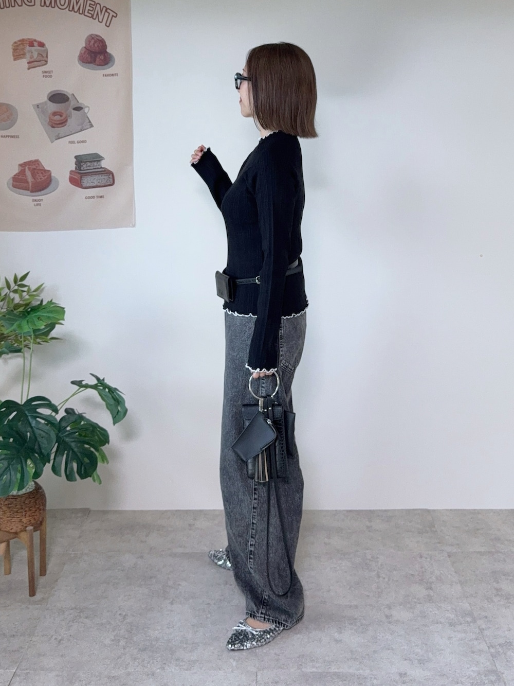 ブラック系のニット/セーター、グレー系のデニムパンツ、ブラック系のベルトを着用したレディースの秋コーディネートの2枚目の写真